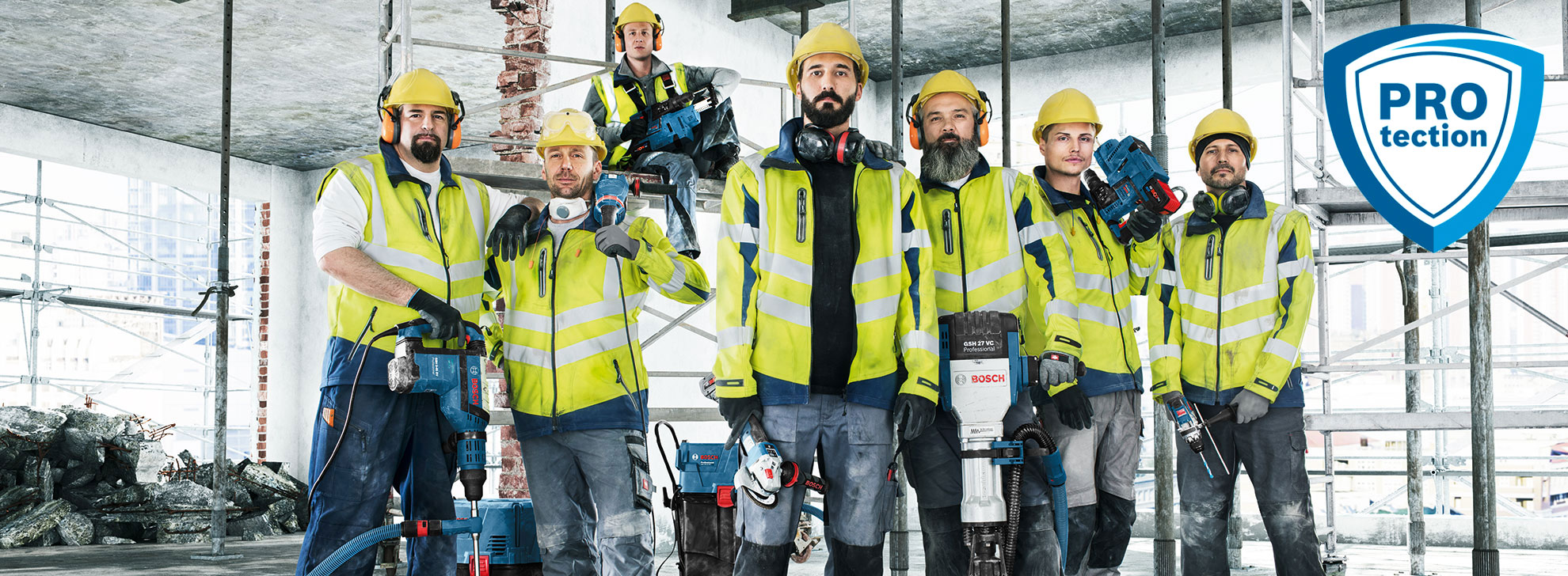 Seven workers in yellow vests stand with Bosch tools on a construction site.