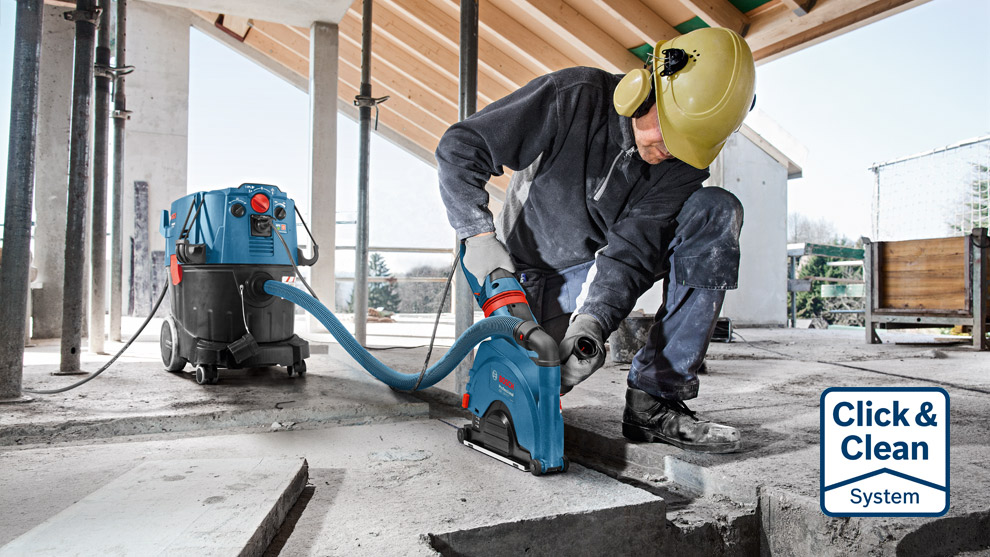 Click & Clean Systems A worker uses a Bosch Professional tool on a concrete surface at a construction site.