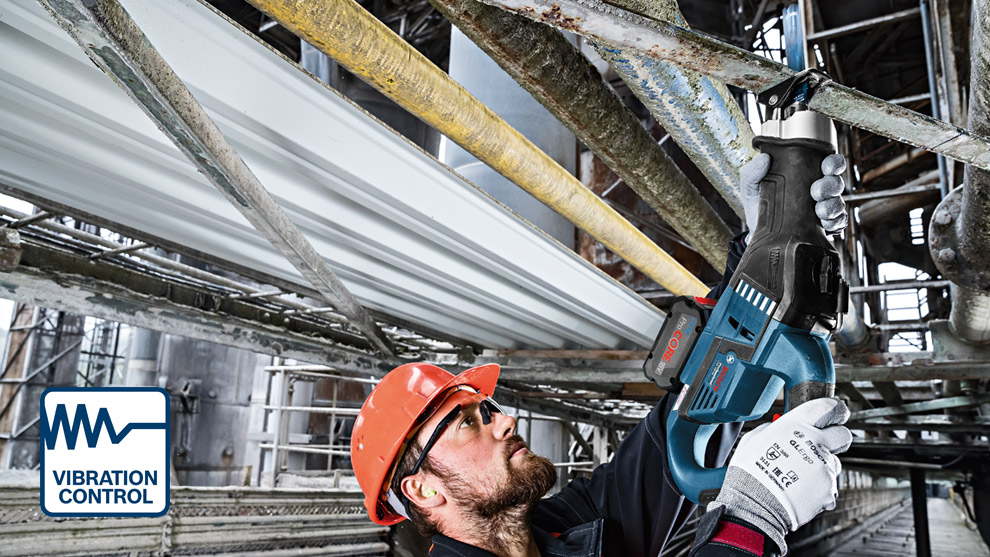 Vibration Control A worker uses a blue Bosch Professional tool, wearing a helmet and gloves, in a factory setting.