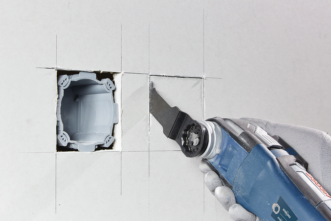 BIM plunge cut saw blade AIZ 20 AB Multi Material Person wearing safety equipment cuts drywall with an oscillating multi-tool.