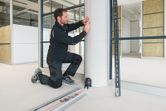 A person in workwear marks a pillar using a laser leveling tool.