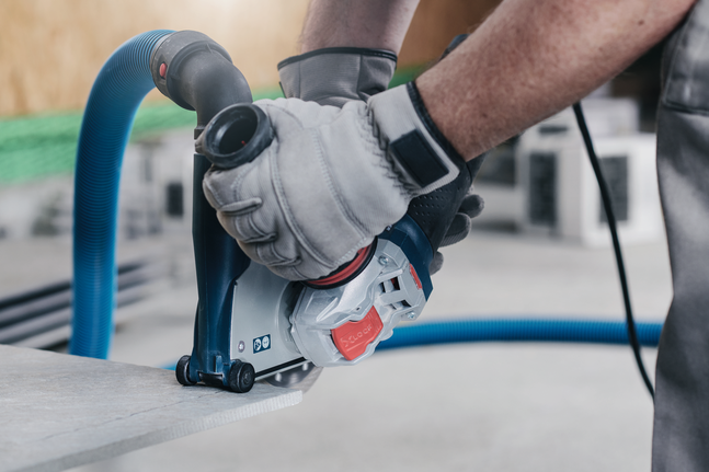 X-LOCK Standard for Ceramic diamond cutting disc 125x22.23x1.6x7 A person wearing safety equipment uses a power cutter with dust extraction on a concrete slab.