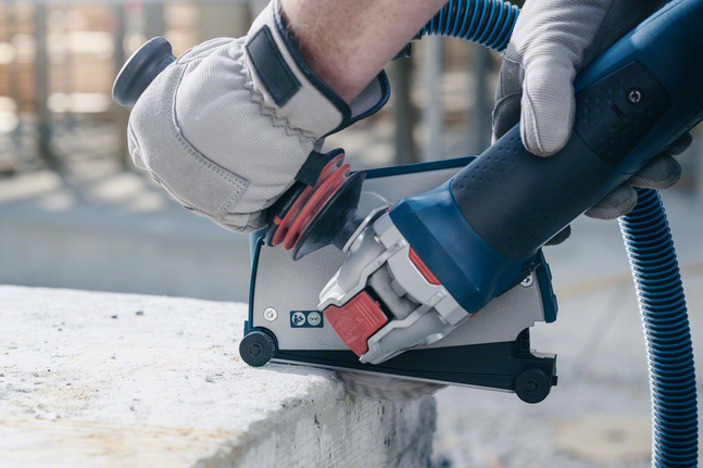 X-LOCK Standard for Ceramic diamond cutting disc 125x22.23x1.6x7 Person wearing safety equipment uses a power tool to cut concrete.