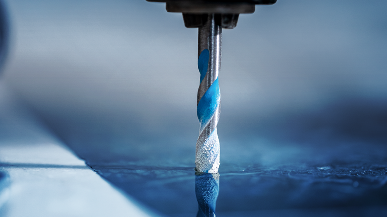 EXPERT HEX-9 MultiConstruction Drill Bit Set 5/6/8 mm 3-pc Drill bit making a hole in a reflective tile surface.