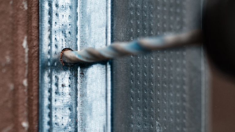 EXPERT MultiConstruction CYL-9 Drill Bit Set 4/5/6/6/8/10/12 mm 7-pc Drill bit making a hole in a metal surface.