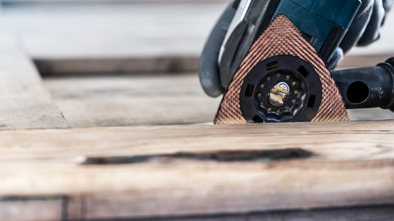 EXPERT Sanding Plate AVZ 90 RT10 Multitool Blade 90 mm Person wearing safety equipment sanding wood with a multi-tool.