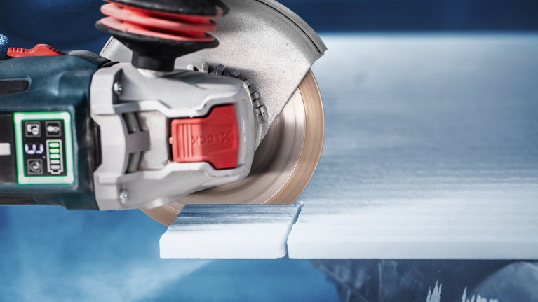 EXPERT HardCeramic X-LOCK Diamond Cutting Disc 115 x 22.23 x 1.4 x 10 mm Circular saw cutting through a white tile slab.