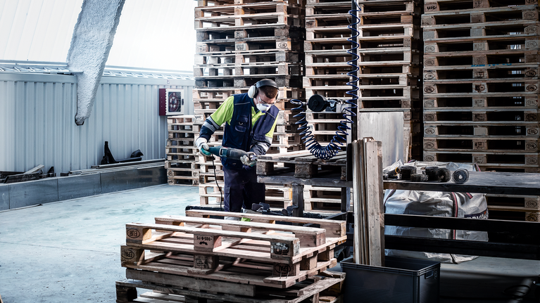 EXPERT Hard Nail Pallets S1122CHM Reciprocating Saw Blade 1-pc A person wearing safety equipment uses a power tool to cut wood pallets.