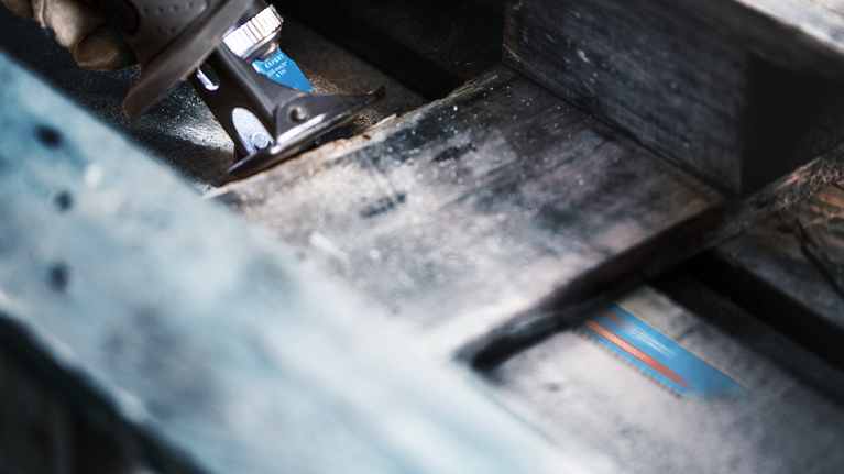 EXPERT Hard Nail Pallets S1122CHM Reciprocating Saw Blade 1-pc Person using a reciprocating saw to cut through a wooden beam.