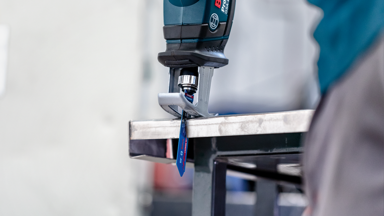 EXPERT ‘Thin Tough Metal’ S 522 EHM Reciprocating Saw Blade 1-pc A person wearing safety equipment cuts a metal sheet with a reciprocating saw.