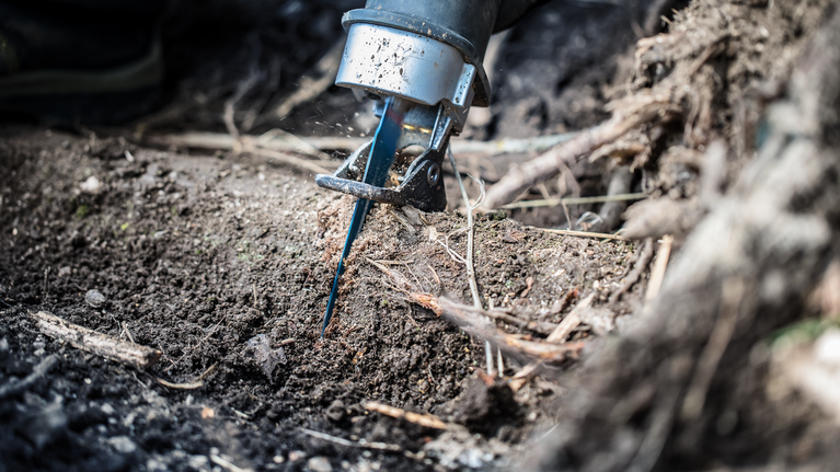 EXPERT ‘Tough Wood’ S 1142 KHM Reciprocating Saw Blade 1-pc Reciprocating saw cutting through a tree root in the soil.