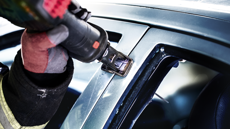 EXPERT ‘Vehicle Rescue’ S 1157 CHM Reciprocating Saw Blade 1-pc A person wearing safety equipment uses a power tool to cut a car window frame.