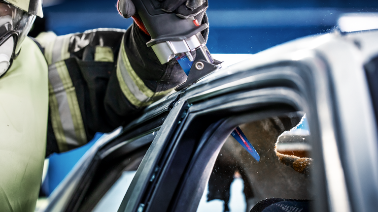 EXPERT ‘Vehicle Rescue’ S 1157 CHM Reciprocating Saw Blade 1-pc A person wearing safety equipment cuts through a car roof using a reciprocating saw.