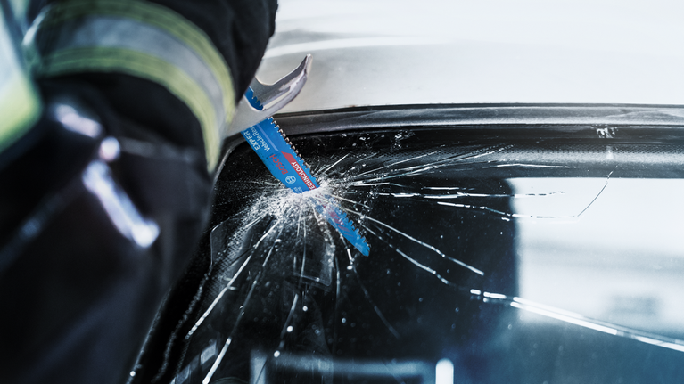 EXPERT ‘Vehicle Rescue’ S 957 CHM Reciprocating Saw Blade 1-pc Person wearing safety equipment cuts a cracked car windshield with a reciprocating saw blade.