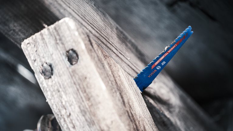 EXPERT Wood with Metal Demolition S967XHM Reciprocating Saw Blade 1-pc Saw blade cutting through a thick wooden plank.