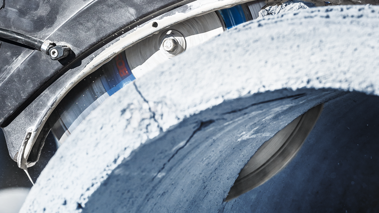 EXPERT MultiMaterial Diamond Cutting Disc 350 x 20/25.40 x 3.3 x 15 mm A large saw blade cuts through a thick concrete pipe.