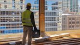 Construction worker overlooking city.