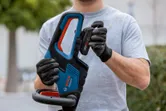Person wearing safety equipment inserts a battery into a cordless power tool.