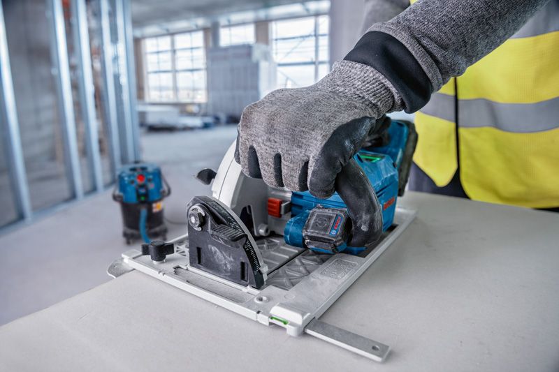 GCT 30-42 A person wearing safety equipment operates a circular saw to cut a panel.