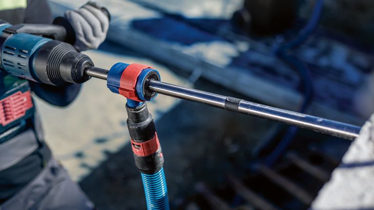 EXPERT SDS Clean plus-8X Hammer Drill Bit 20 x 400 x 550 A person wearing safety equipment uses a rotary tool to drill into concrete.