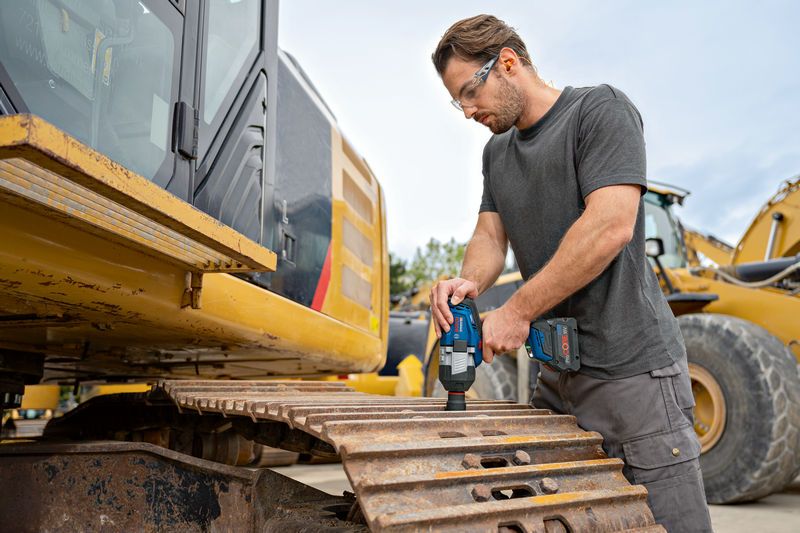 GDS 18V-1600 HC A person wearing safety equipment uses a cordless impact wrench on an excavator track.