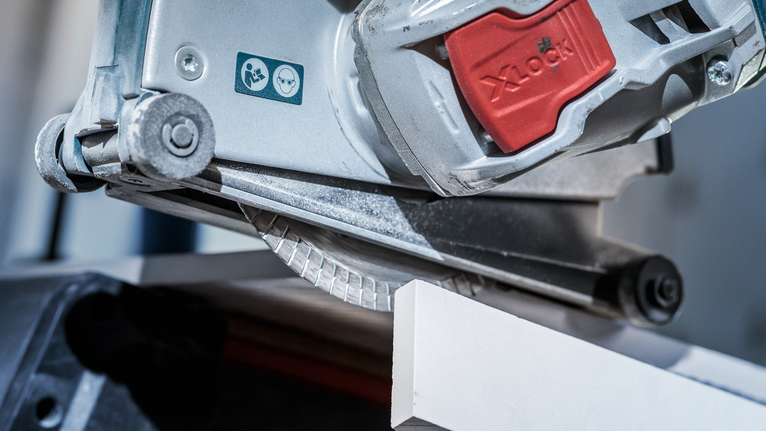 PRO Ceramic X-Lock Diamond Disc, 125 x 22.23 mm, 22.23 mm Circular saw cutting a white tile with a safety warning label visible.