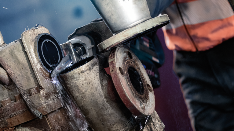 PRO Thick Metal Demolition S930CF Blade, 1.6 x 22 x 150 mm, 5 pcs A person wearing safety equipment uses a grinder to cut a metal pipe with water cooling.