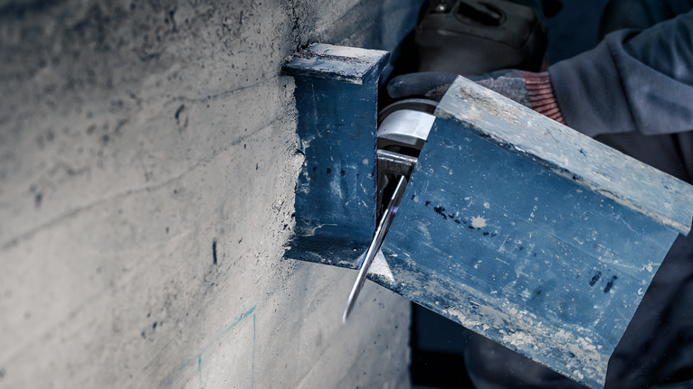 PRO Thick Metal Demolition S930CF Blade, 1.6 x 22 x 150 mm, 5 pcs Person wearing safety equipment cuts a steel beam with a power tool.