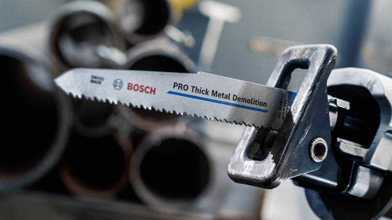 PRO Thick Metal Demolition S930CF Blade, 1.6 x 22 x 150 mm, 5 pcs Reciprocating saw with a demolition blade positioned near metal pipes.