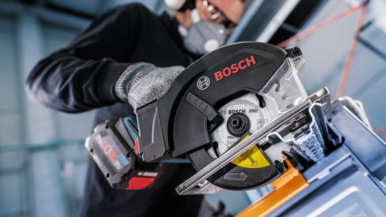 PRO Steel cordless Circular Saw Blade, 136 x 1.6 x 20 mm A person wearing safety equipment uses a circular saw to cut metal.