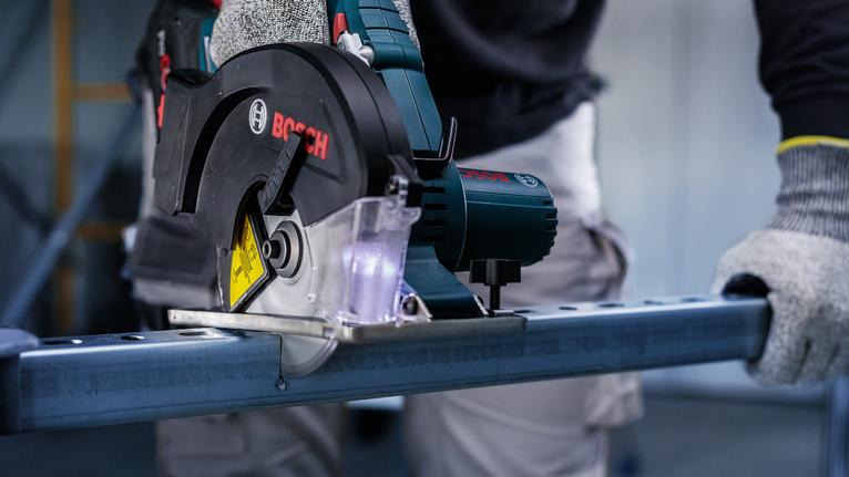 PRO Steel cordless Circular Saw Blade, 136 x 1.6 x 20 mm A person wearing safety equipment cuts metal with a circular saw.