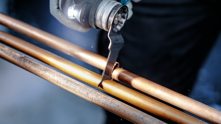 PRO AIZ 32 AIB Plunge Cut Blade, 32 x 50 mm, 5 pcs Person using an oscillating tool to cut a copper pipe.