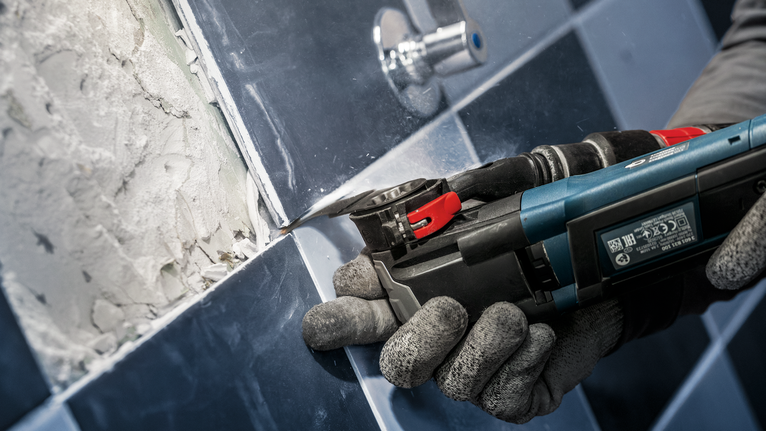 PRO MATI 68 RT3 Multitool Blade, 2.8 x 68 mm Person wearing safety equipment removes grout from tiles using a power multitool.