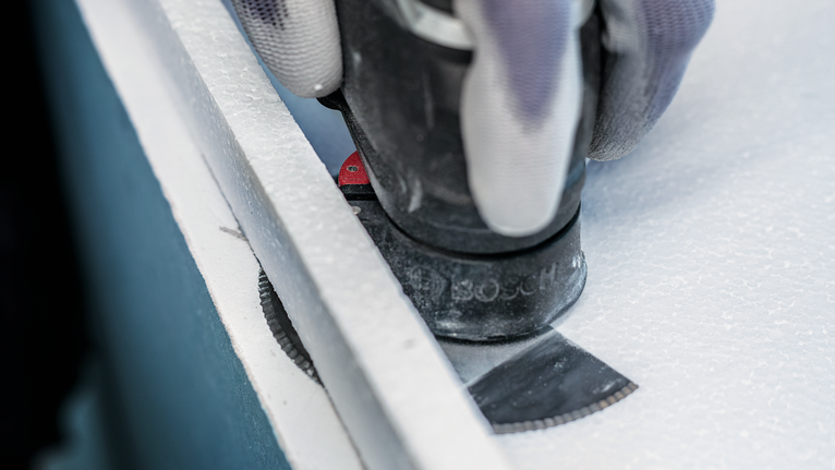 PRO ACZ 100 SWB Multitool Blade, 100 mm Person wearing safety equipment cuts a panel board with a multi-tool blade.