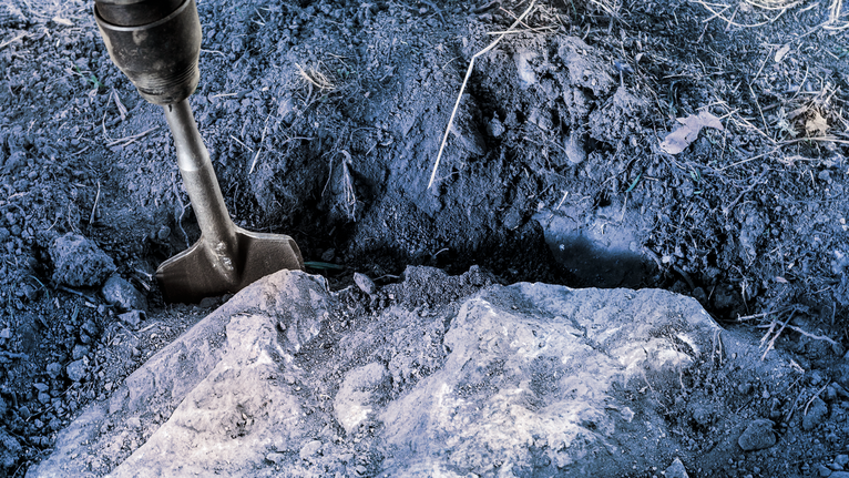 PRO SDS max Excavation Chisel, 110 x 400 mm Chisel bit breaking hard soil and rock in a trench outdoors.