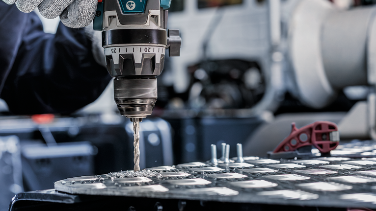 PRO Metal HSS-G Twist Drill Bit, 1/4 x 63 x 101 mm A person wearing safety equipment drills holes into a metal sheet.