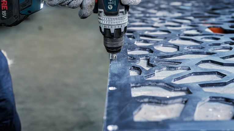 PRO Steel HSS Countersink Bit, 12 x 40 mm, M6 Person wearing safety equipment drills into a patterned metal sheet.
