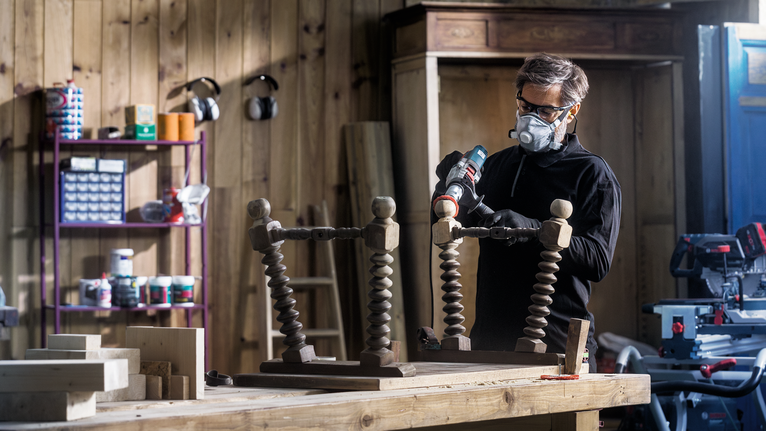 PRO Multi Material clean Cup Brush, 75 x 1 mm, Straight Shank Person wearing safety equipment drills into an upside-down wooden table in a workshop.