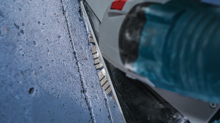 Diamond blade cutting a straight groove into a concrete surface.