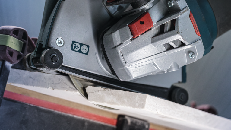 PRO Marble Diamond Disc, 115 x 22.23 mm Power tool cutting through a ceramic tile on a workbench.