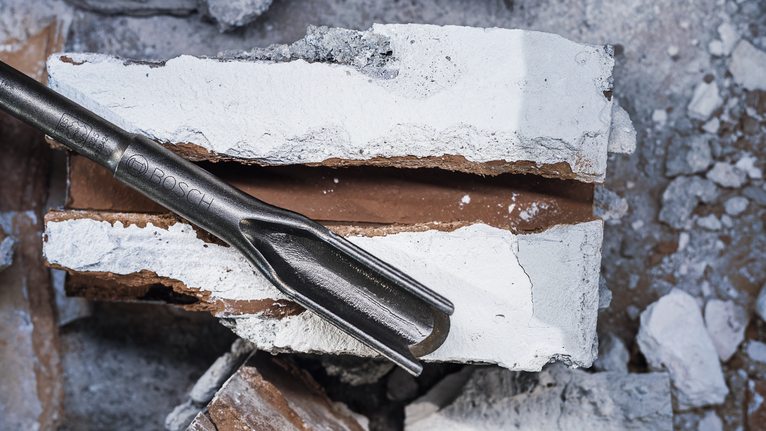 PRO SDS max Hollow Gouging Chisel, 32 x 300 mm Chisel tool breaking through a concrete block.
