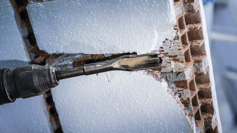 PRO SDS max Hollow Gouging Chisel, 32 x 300 mm Rotary hammer chisel breaking a hole through a white brick wall.