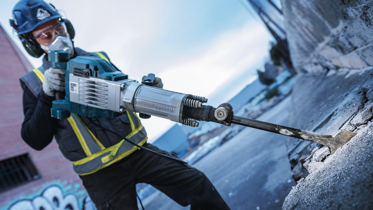 PRO HEX 30-4C Spade Chisel, 75 x 450 mm A person wearing safety equipment uses a demolition tool to break concrete.