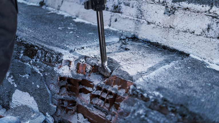 PRO HEX 30-4C Spade Chisel, 75 x 450 mm Demolition tool breaking concrete on a brick wall.