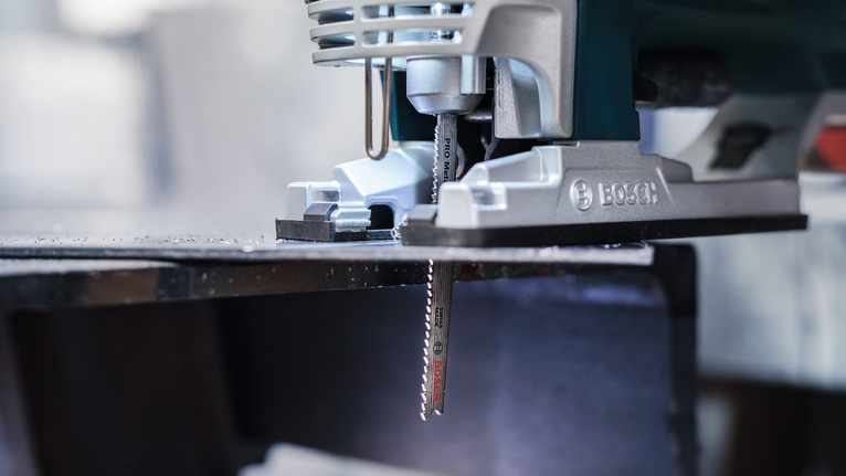 PRO Metal thick and thin T123XF Jigsaw Blade, 100 mm, 5 pcs Jigsaw cutting through a metal sheet in a workshop.