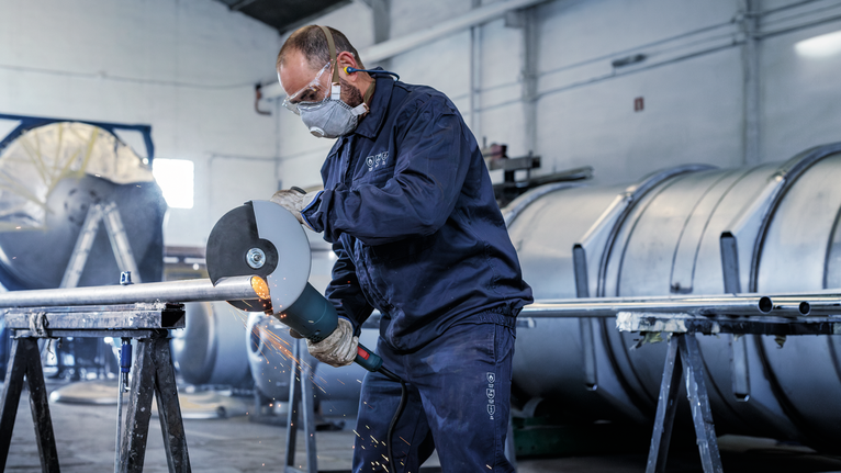 PRO Stainless Steel and Metal Bonded Cutting Disc, 180 x 1.6 x 22.23 mm, Straight, oSa A person wearing safety equipment grinds a metal pipe, creating sparks.