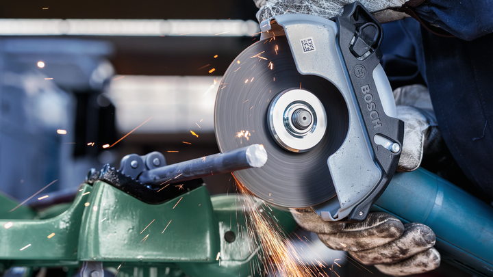 Object #200467092: 3089912_app_web_1 Worker wearing safety equipment cuts metal pipe with a handheld power cutter.