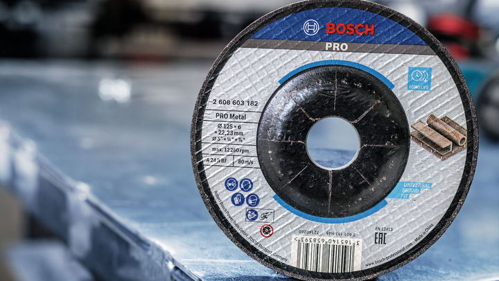 Cutting disc for metal positioned upright on a metal work surface.