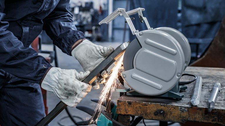 PRO Metal Grinding Wheel, 200 x 25 x 32 mm, G46 A person wearing safety equipment grinds metal, producing sparks on a workbench.