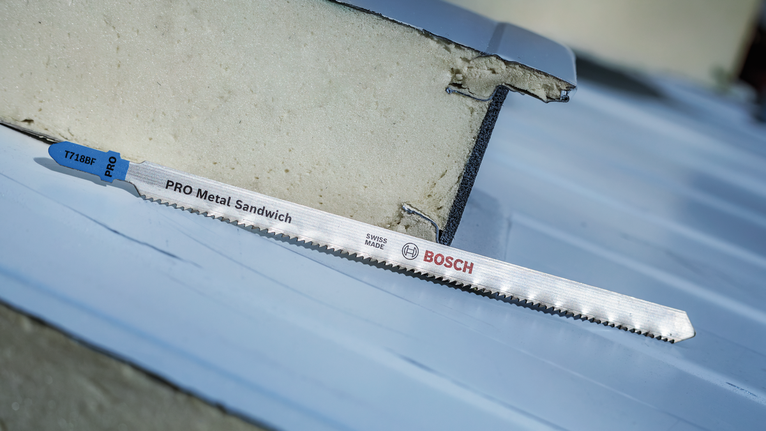 PRO Metal Sandwich T718BF Jigsaw Blade, 180 mm, 3 pcs Saw blade for metal sandwich panels rests on a sheet surface outdoors.